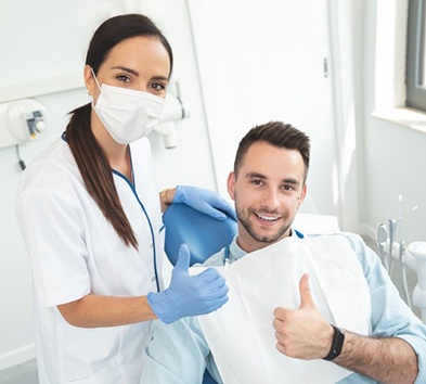 a dentist and patient giving a thumbs-up
