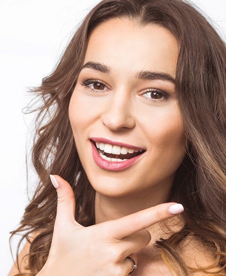 Beautiful woman using fingers to showcase her nice smile
