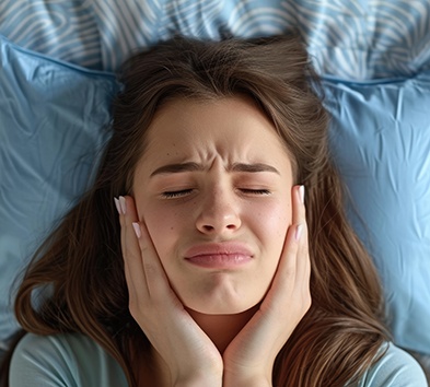 Woman lying in bed, suffering from TMJ disorder