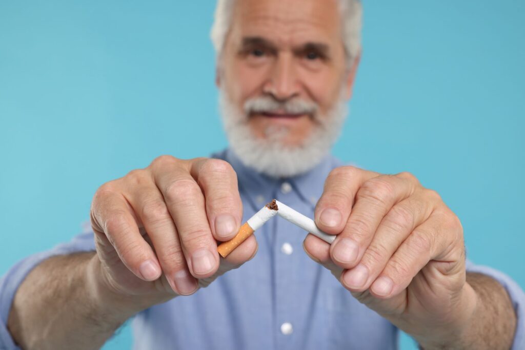 A man breaking a cigarette in half